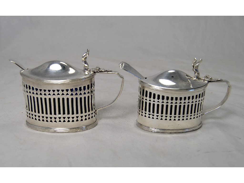 Appraisal: Two silver oval pierced mustards both with blue glass liners