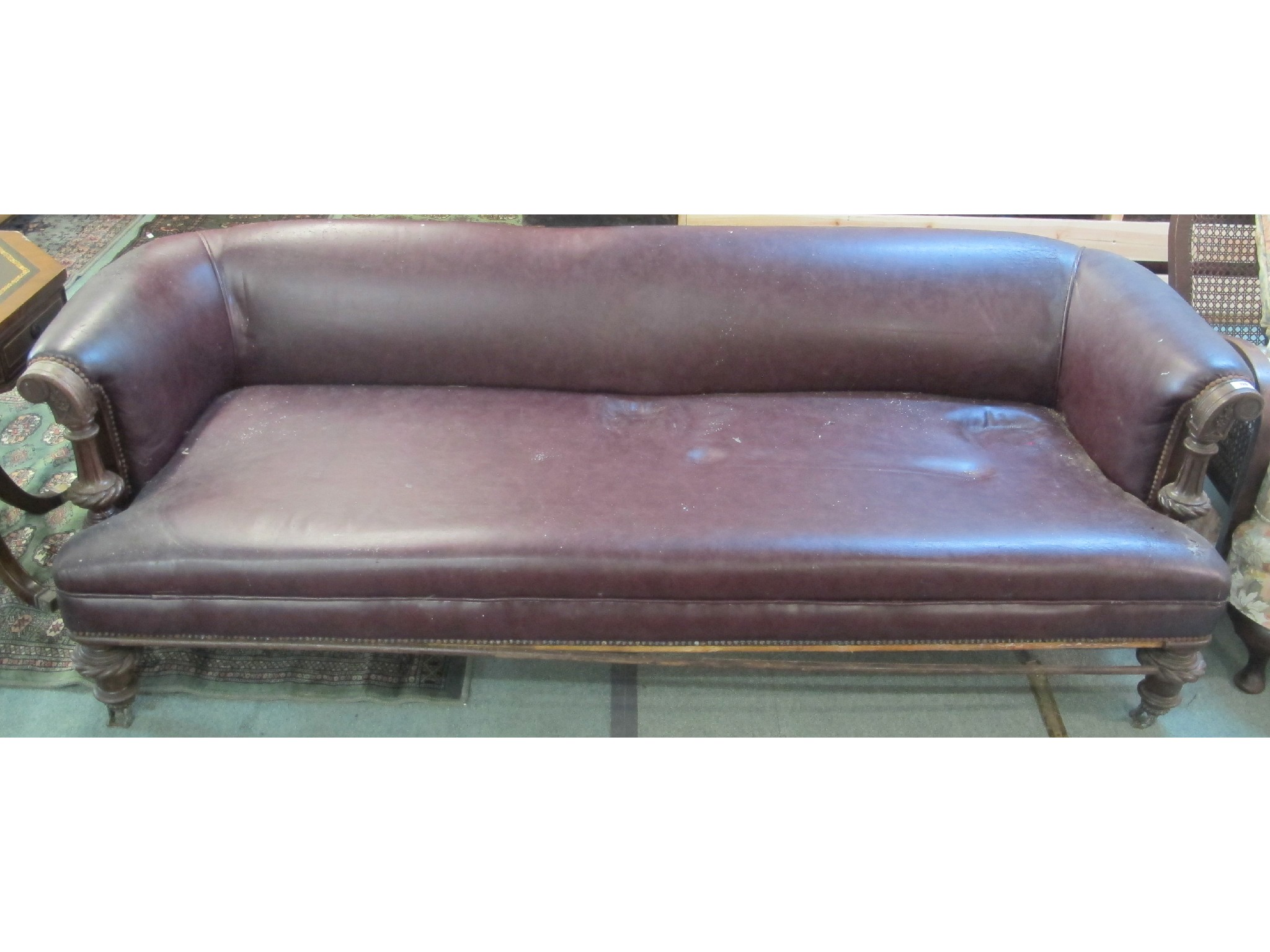 Appraisal: A Victorian leather scroll back settee with mahogany frame