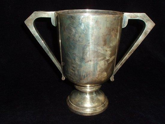 Appraisal: A trophy cup circular with stylized handles cm high Walker