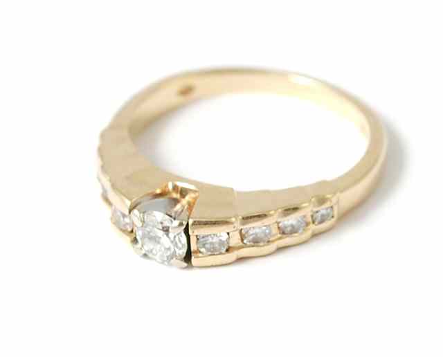 Appraisal: DIAMOND AND FOURTEEN KARAT GOLD RING centering a round-cut diamond