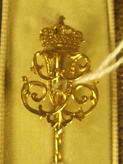 Appraisal: A GOLD STICK PIN in the form of a crowned