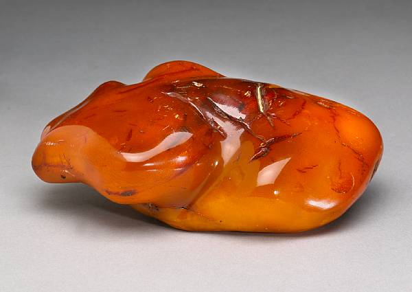 Appraisal: An amber specimen Of uneven cloud-like contour displaying areas of