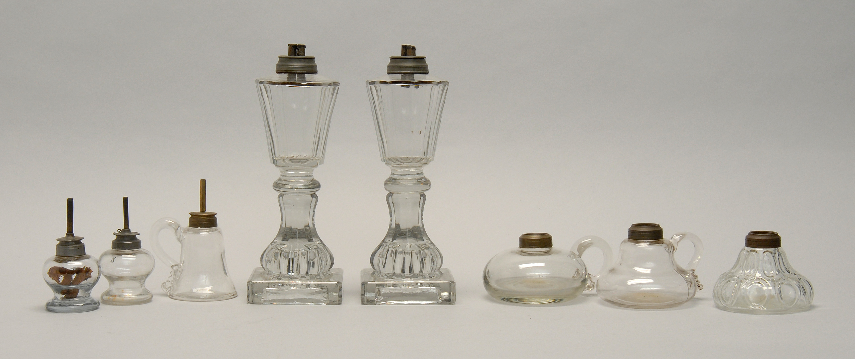 Appraisal: EIGHT TH CENTURY CLEAR GLASS LAMPS a pair of panel-cut