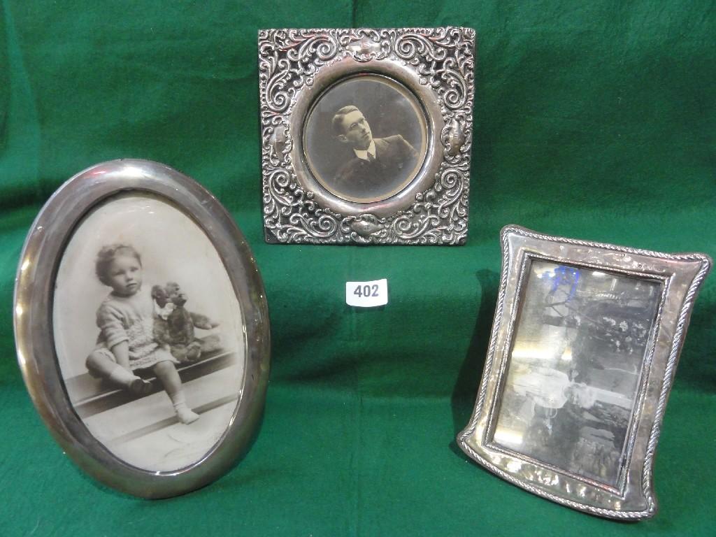 Appraisal: A heavily scrolled silver photo frame together with two other