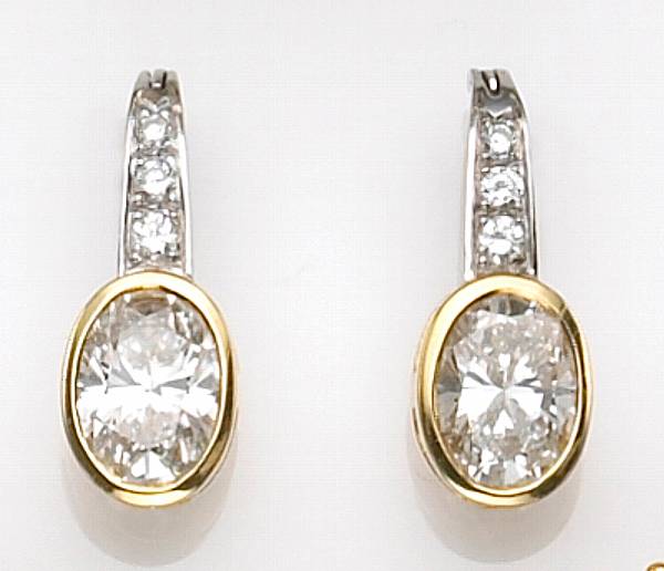 Appraisal: each with a bezel-set oval-shaped diamond suspended from a three-stone