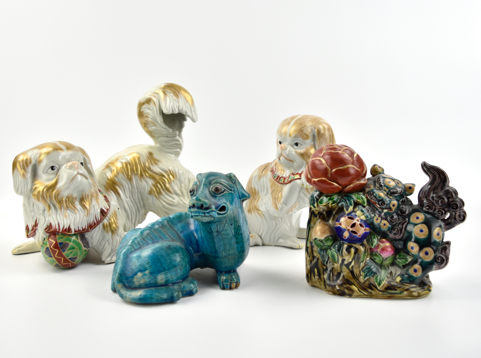 Appraisal: Chinese four porcelain foo-dog modeled statues one with its front