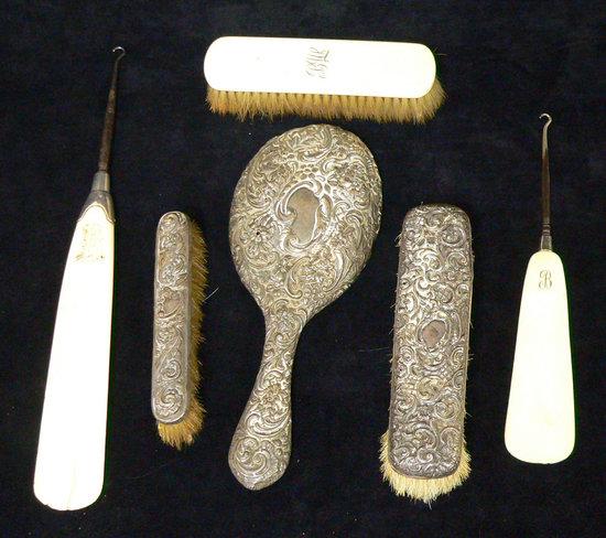 Appraisal: A silver backed hand mirror with embossed decoration two clothes