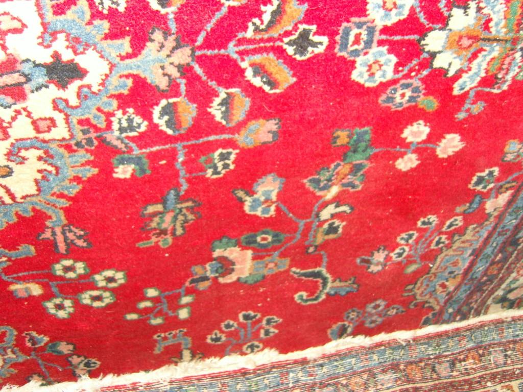 Appraisal: A large red ground wool carpet with polychrome and stylised