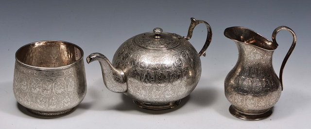 Appraisal: A PERSIAN SILVER THREE PIECE TEASET intricately engraved with oval