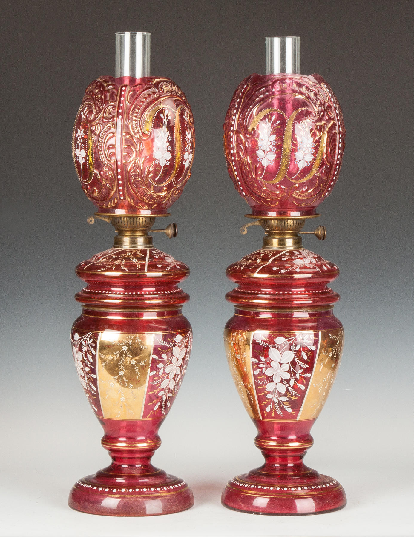 Appraisal: Pair of Victorian Cranberry Enameled Gilded Oil Lamps th cent