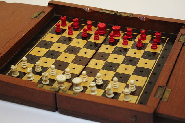 Appraisal: AN EDWARDIAN TRAVELLING CHESS SET contained within a mahogany folding