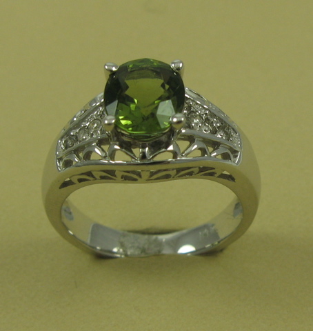 Appraisal: PERIDOT DIAMOND AND K WHITE GOLD RING centering an oval-cut