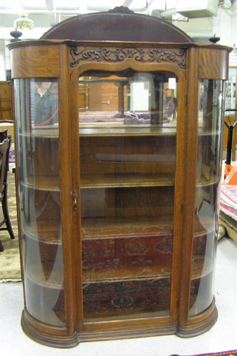 Appraisal: AN OAK AND CURVED GLASS CHINA CABINET American late th