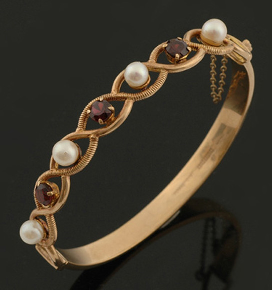 Appraisal: A cultured pearl and garnet bangle The hinged bangle set