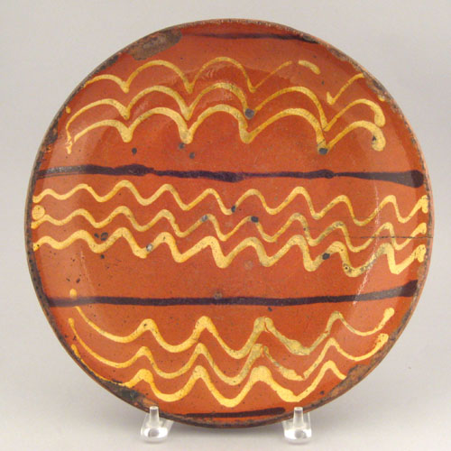 Appraisal: Redware charger th c with yellow slip swag decoration signed