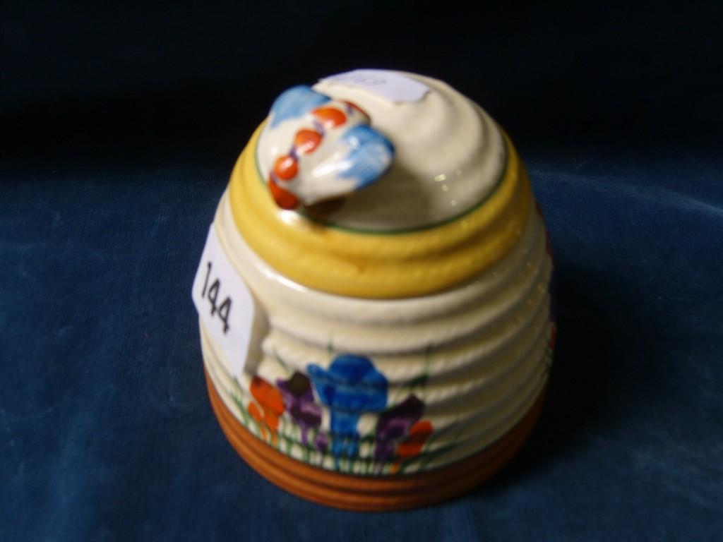 Appraisal: A Clarice Cliff Bizarre honey pot and cover modelled as