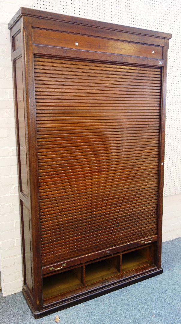 Appraisal: An early th century French oak tambour front cupboard with