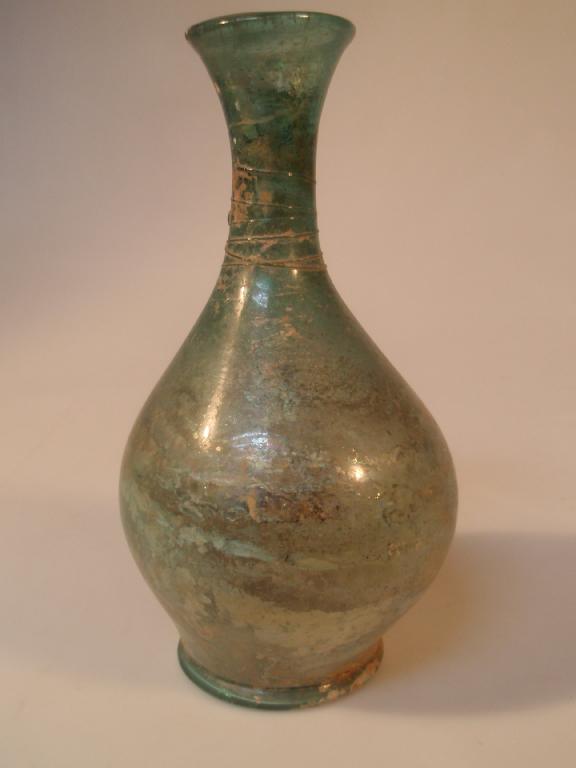 Appraisal: A tall late Roman green glass flask the flaring mouth