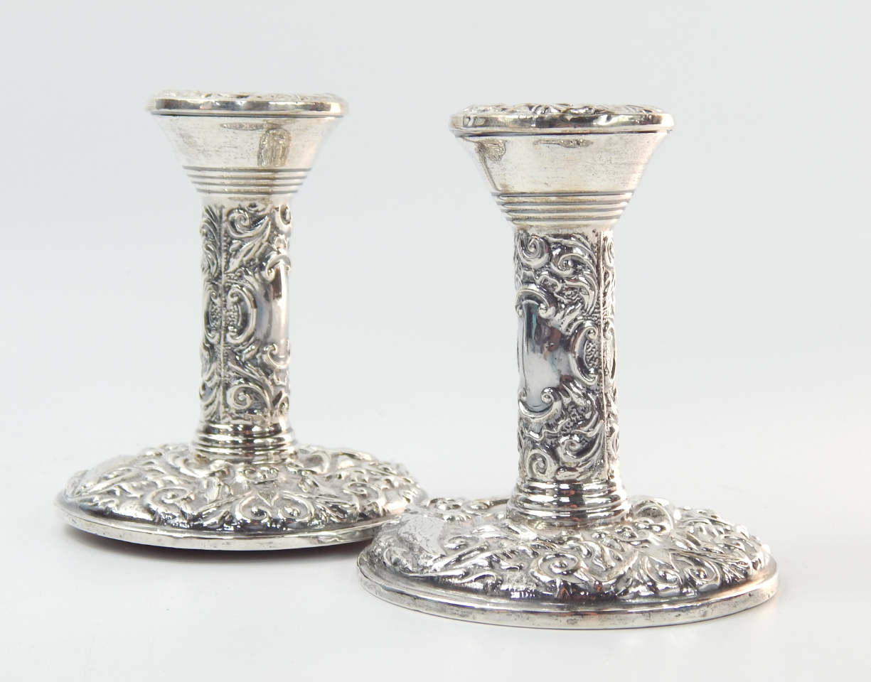 Appraisal: A pair of loaded silver candlesticks embossed with birds and