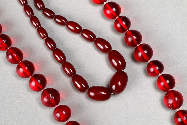 Appraisal: THREE FAUX RED AMBER BEAD NECKLACES graduated necklace long two