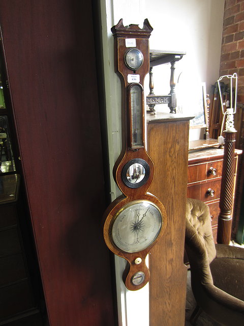 Appraisal: A MAHOGANY WHEEL BAROMETER with hydrometer thermometer convex mirror and