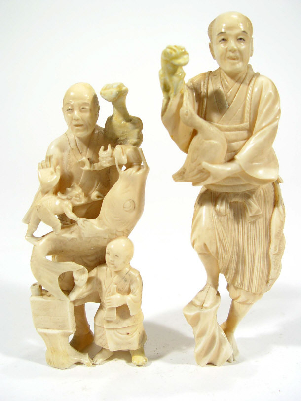 Appraisal: Two Oriental ivory figures carved with a child Dog of