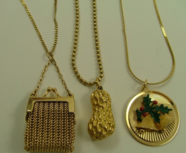 Appraisal: THREE FOURTEEN KARAT GOLD PENDANT NECKLACES including a round holiday