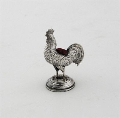 Appraisal: A cockerel pin cushion on a stepped circular base by