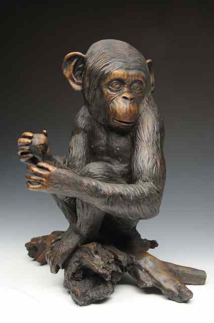 Appraisal: A BRONZE SCULPTURE OF A CHIMPANZEE sitting on a piece