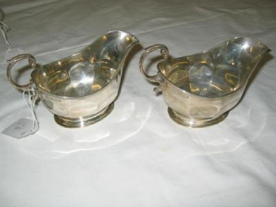 Appraisal: A PAIR OF SAUCE BOATS of panelled oval form with