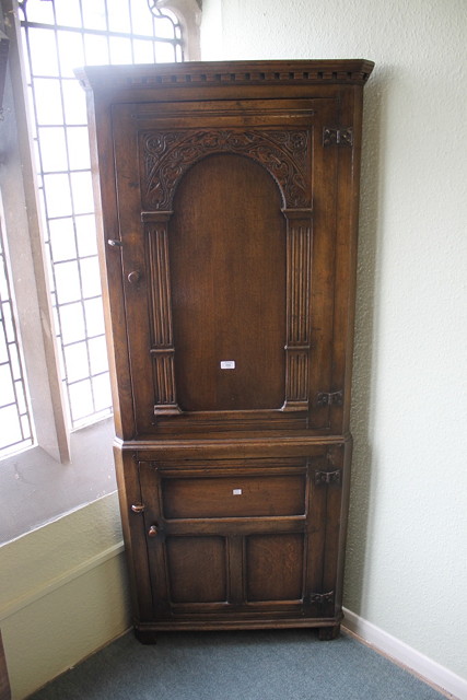 Appraisal: A REPRODUCTION OAK FULL LENGTH CORNER CUPBOARD with arch panel