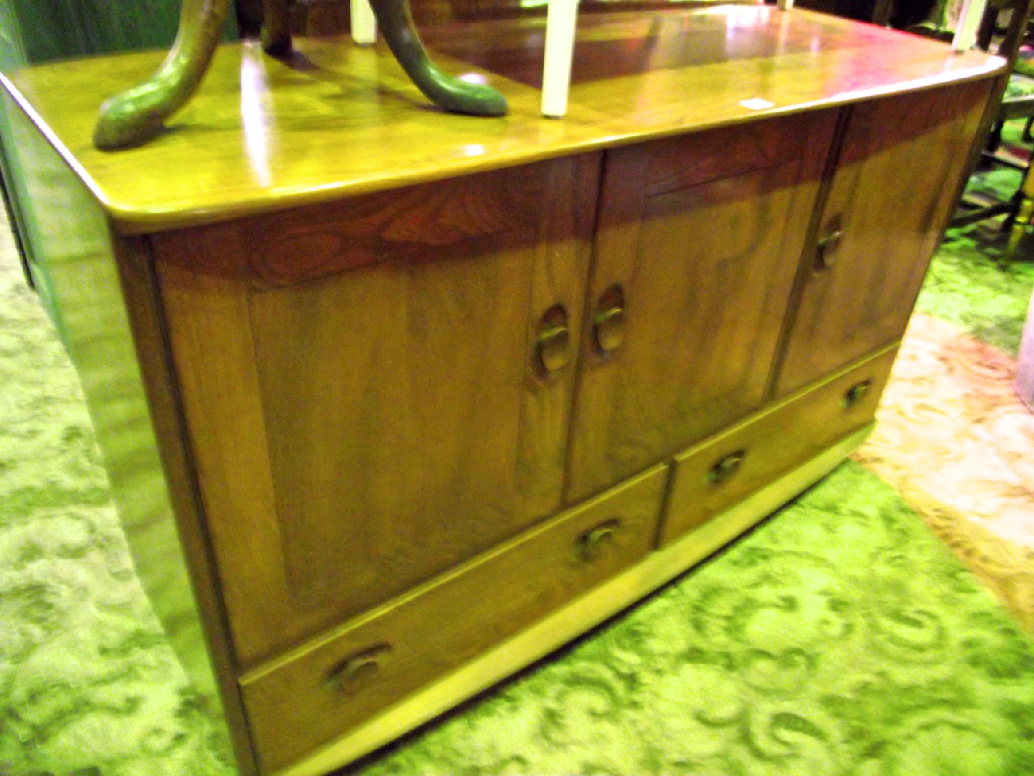 Appraisal: An Ercol medium elm sideboard enclosed by three doors over