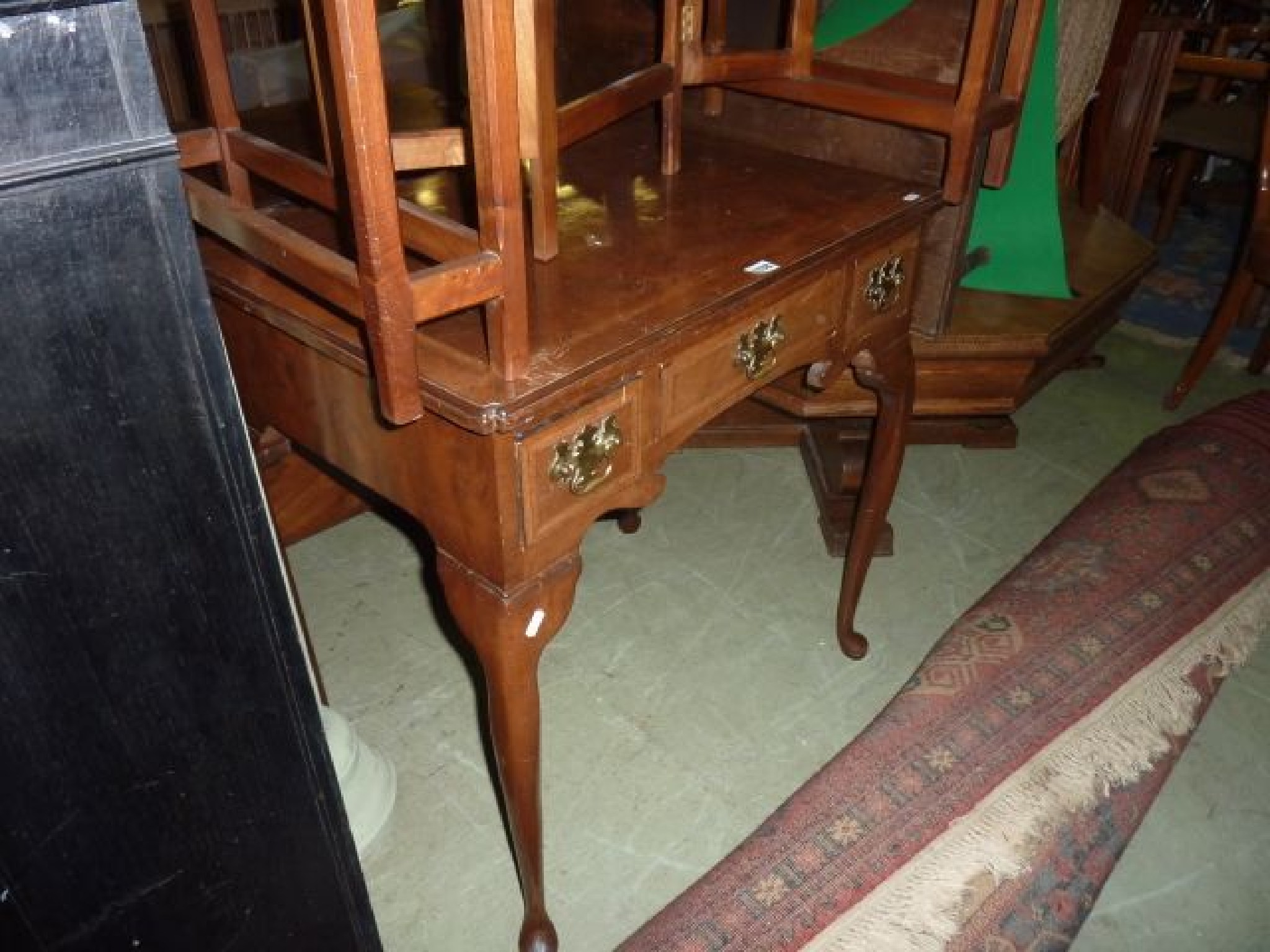 Appraisal: A Georgian style walnut lowboy fitted with three frieze drawers