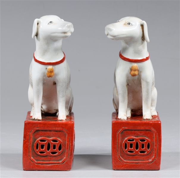 Appraisal: Pair of Chinese opposing white ceramic dog figures on crimson