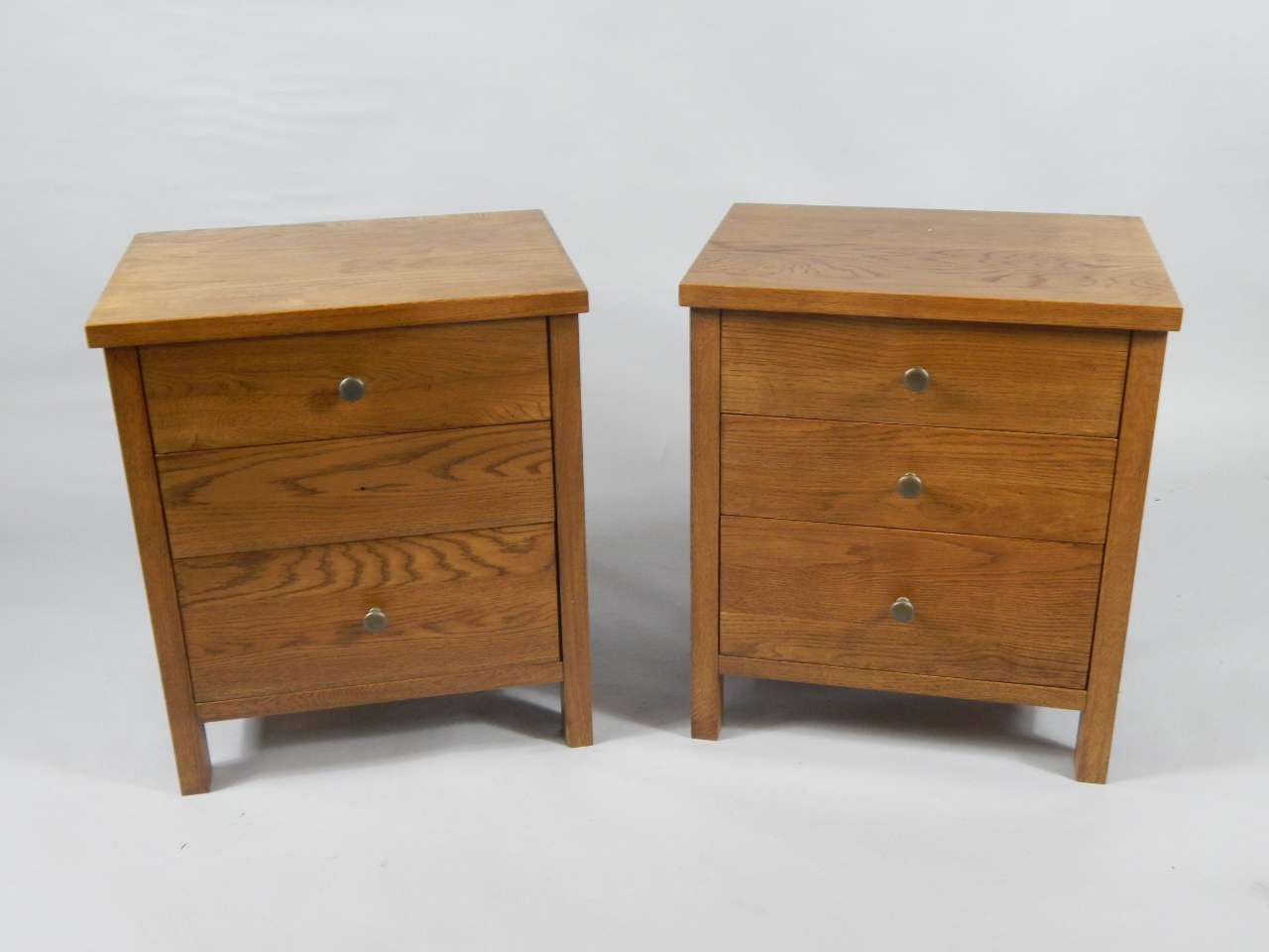 Appraisal: A pair of oak bedside chest of drawers with three