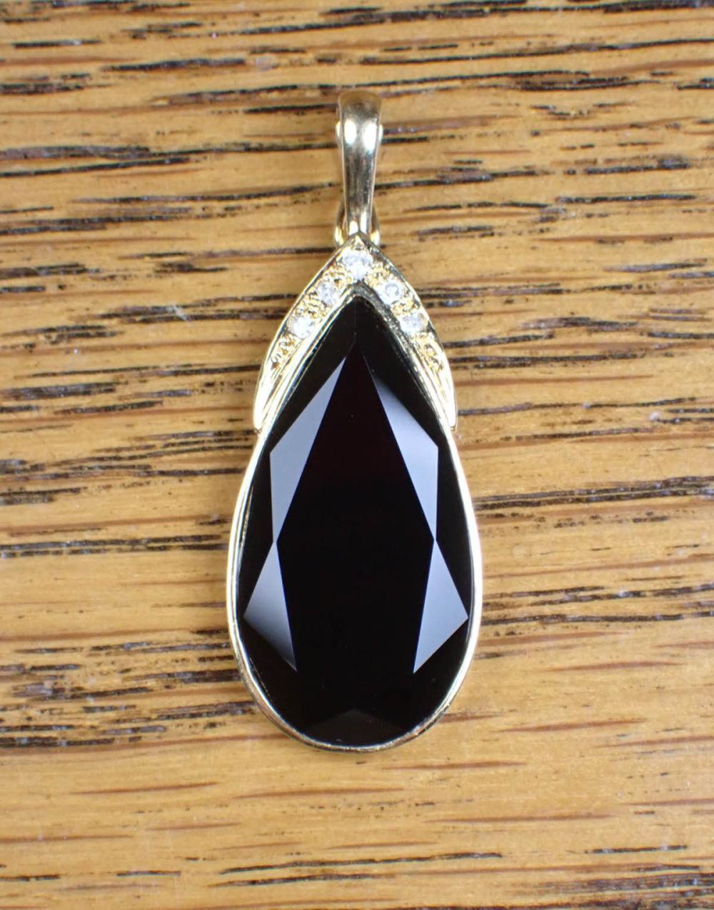 Appraisal: A DIAMOND AND BLACK ONYX PENDANT K yellow gold a