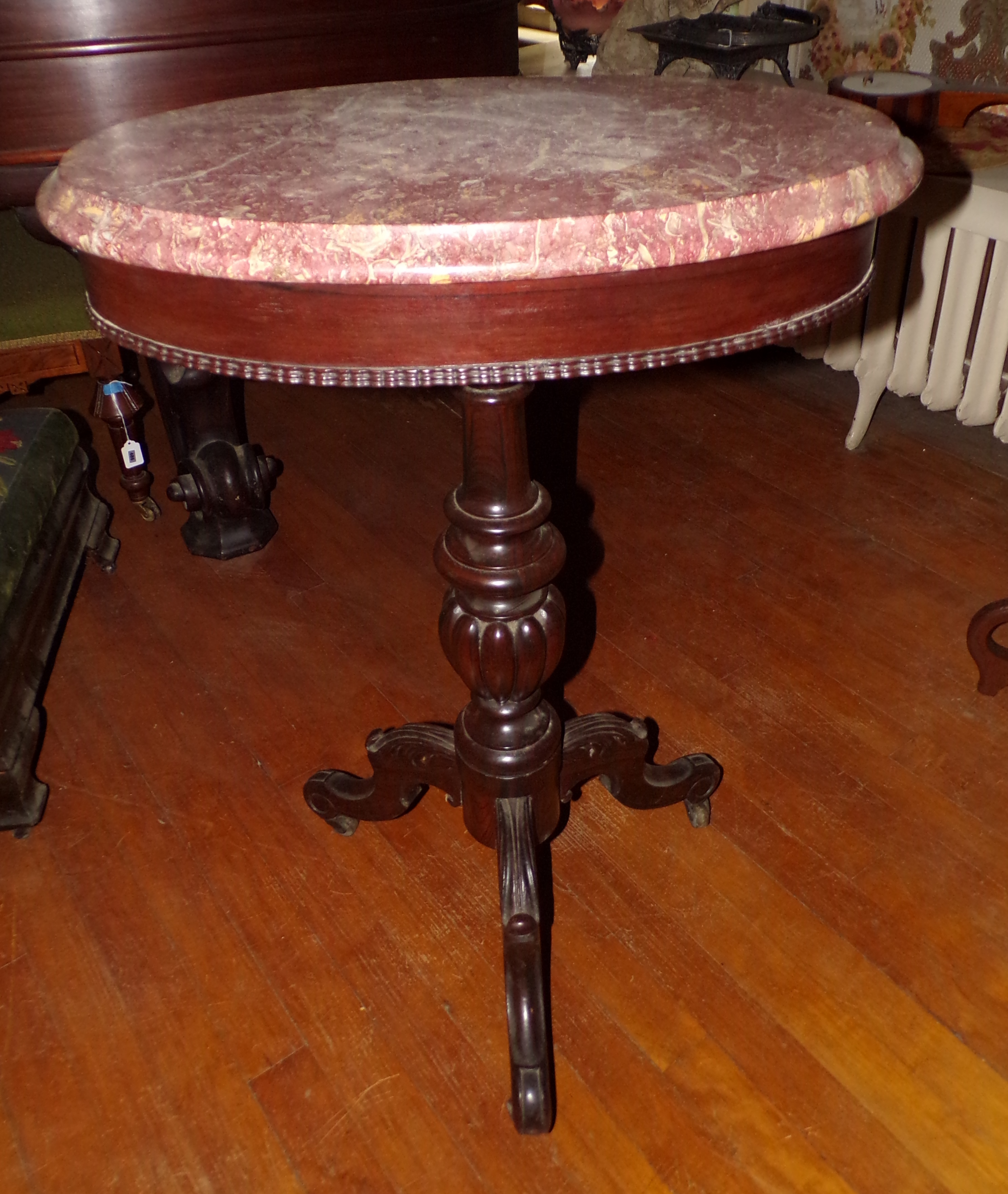 Appraisal: Pink fossilized marble top occasional table turned column support terminating