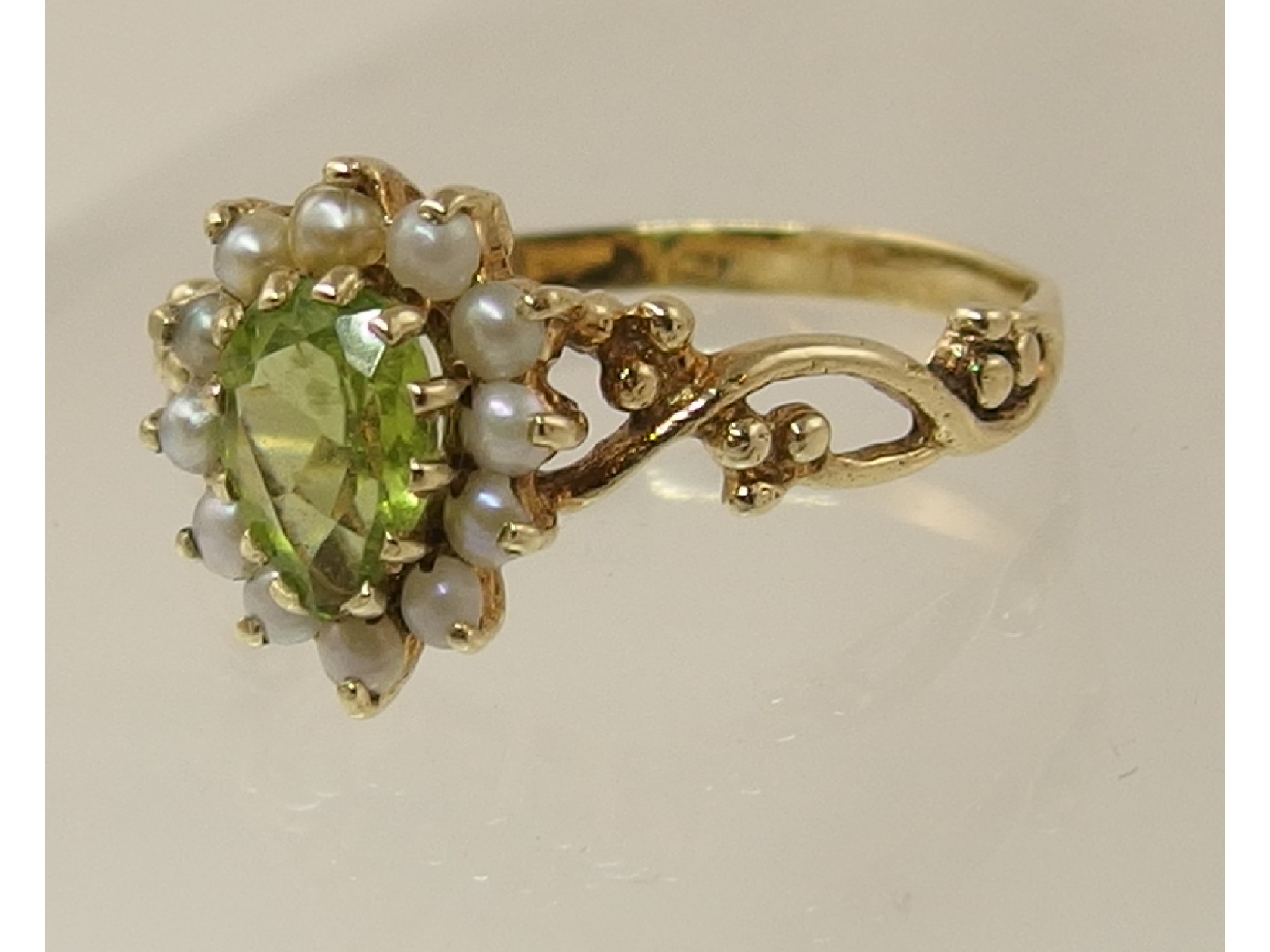 Appraisal: A peridot and split pearl ring with leaf detail to