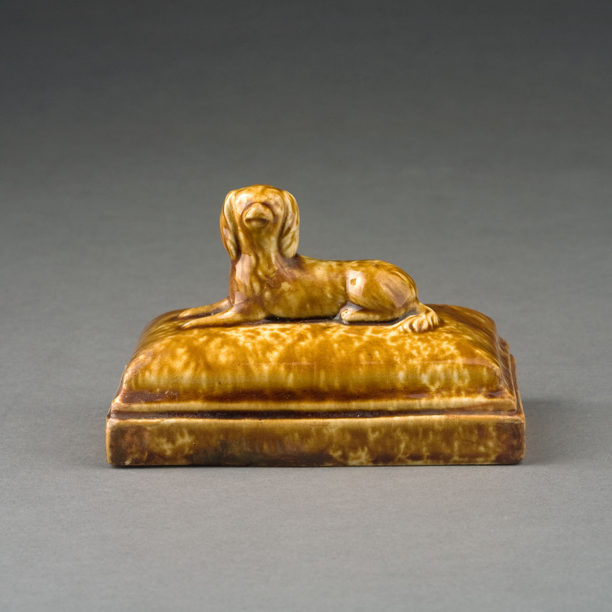 Appraisal: BENNINGTON ROCKINGHAM-GLAZED FIGURAL PAPERWEIGHT IN THE FORM OF A SPANIEL