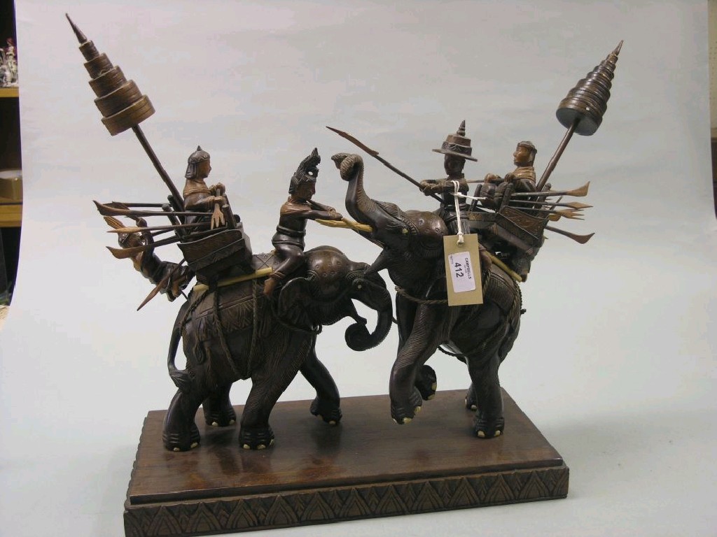 Appraisal: A Tibetan carved wood elephant group depicting a ceremonial occasion