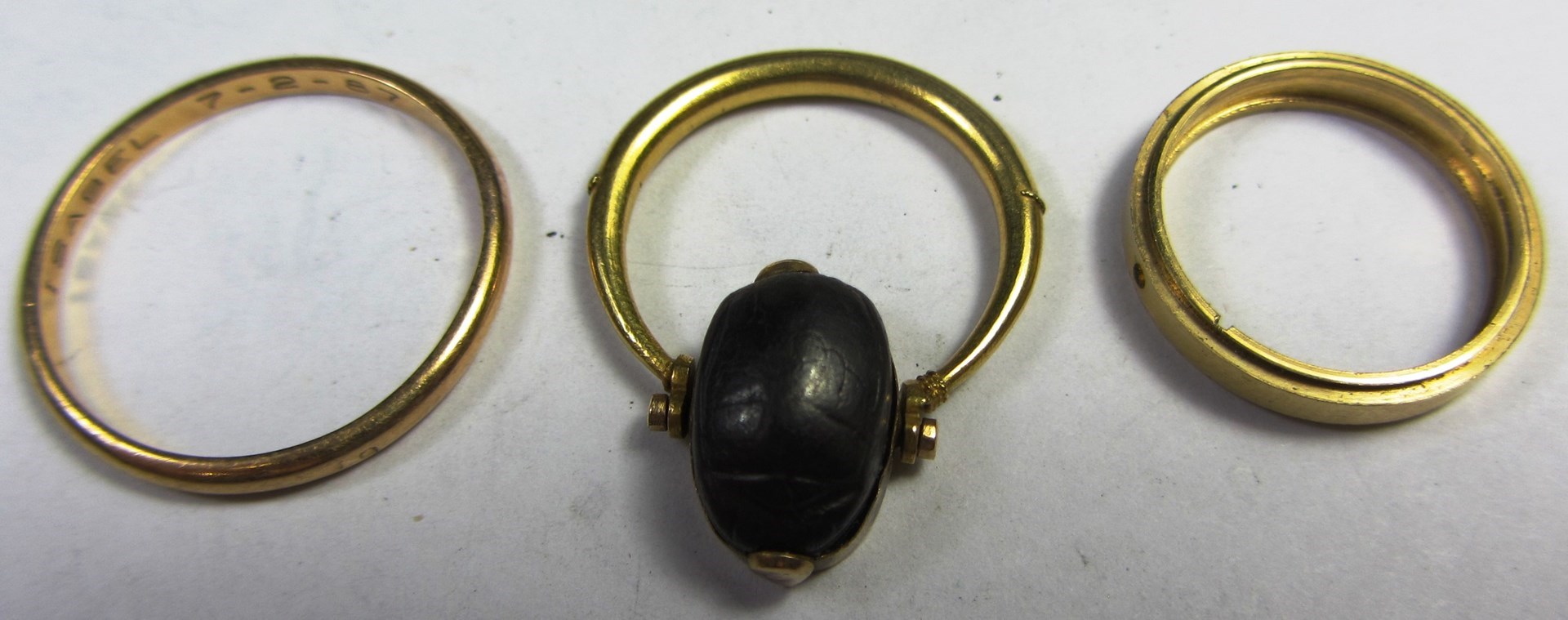 Appraisal: A gold ring mounted with a rotating scarab and two