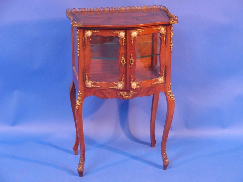 Appraisal: A continental walnut and mahogany serpentine fronted display cabinet with