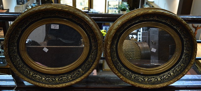 Appraisal: A pair of gilt and ebonised oval wall mirrors cm