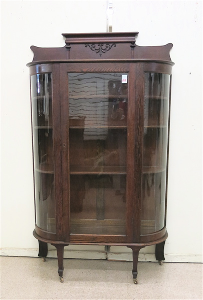 Appraisal: DARK OAK AND CURVED GLASS CHINA DISPLAY CABINET American late