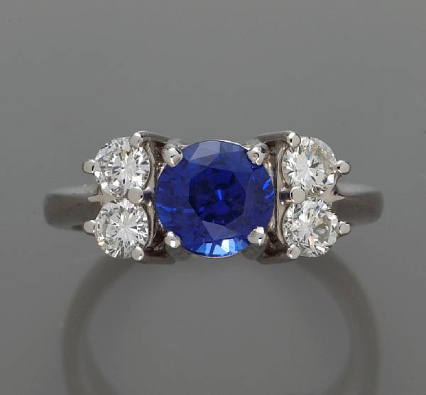 Appraisal: A sapphire and diamond ring centering a circular-cut sapphire mounted