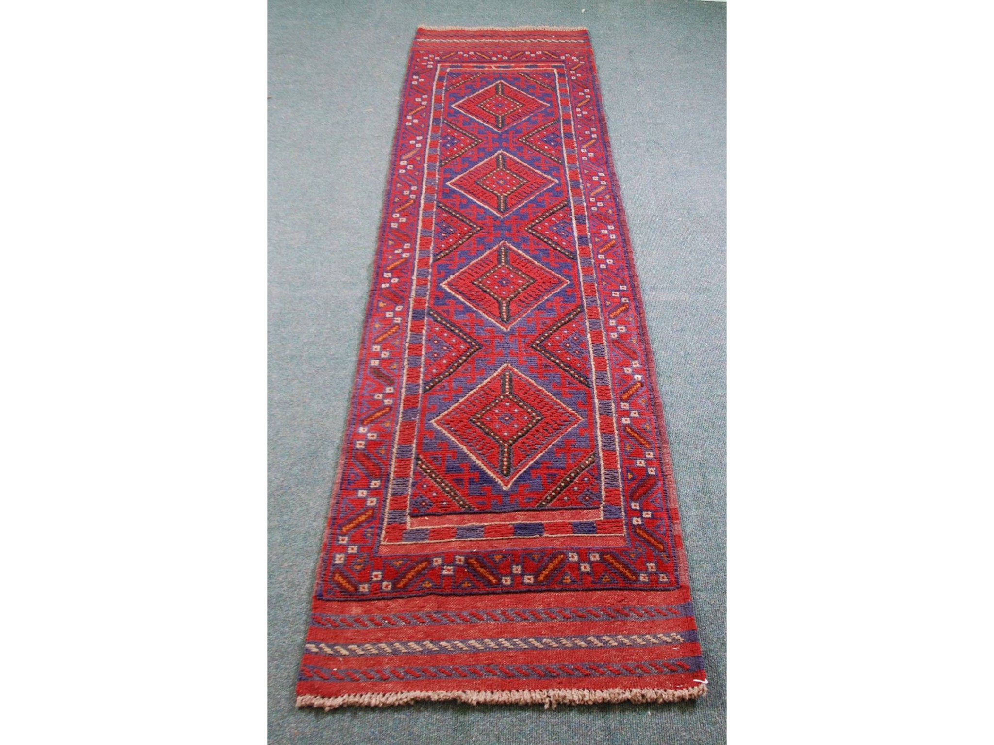 Appraisal: MESHWANI EATERN HAND KNOTTED WOOLLEN RUNNER PRINCIPALLY WINE RED AND