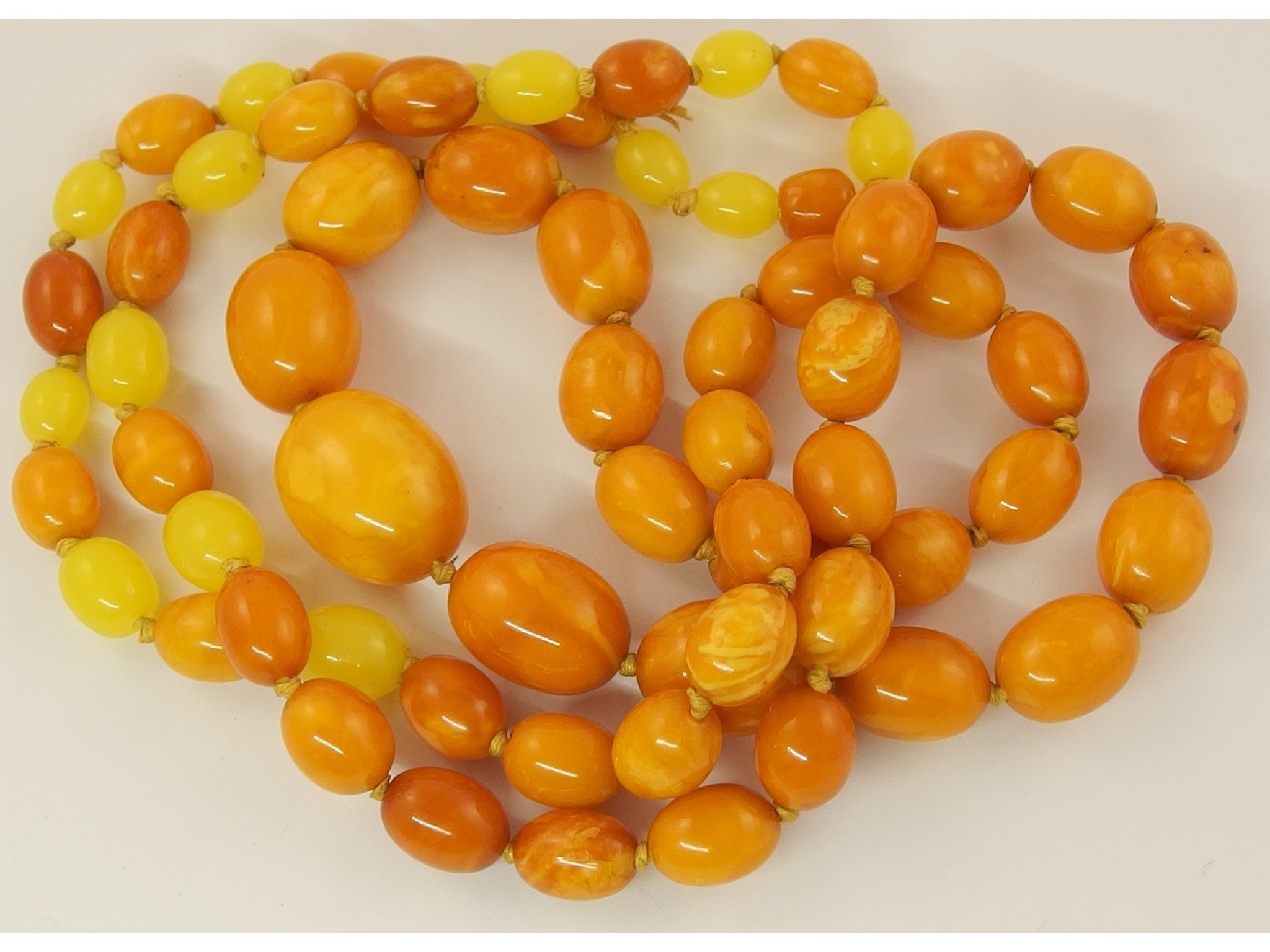 Appraisal: A long string of yellow amber coloured beadsthe extra length