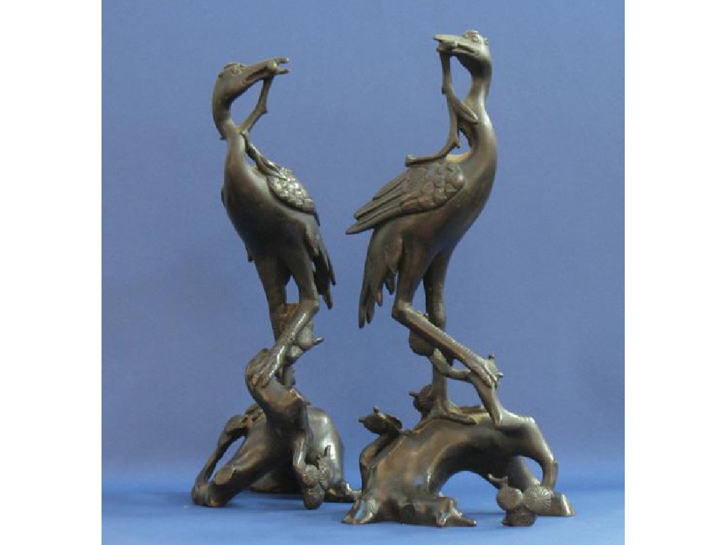 Appraisal: A PAIR OF CHINESE BRONZE CRANES standing on gnarled branches