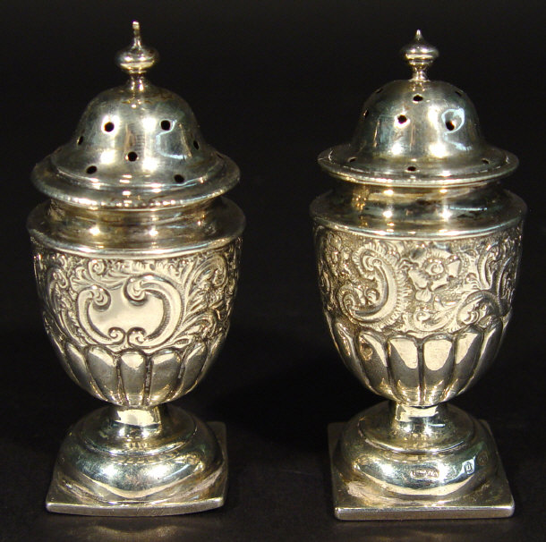 Appraisal: Two silver pepperettes embossed with flowers and fleurs-de-lys Birmingham each