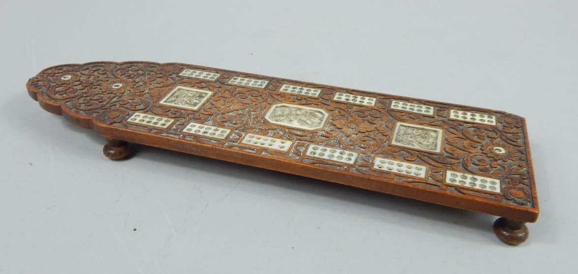 Appraisal: A heavily carved Indian hardwood cribbage board picked out with